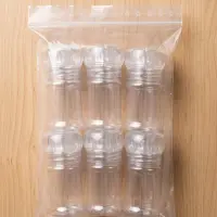 Six empty transparent 50 ml chili mills in a plastic bag